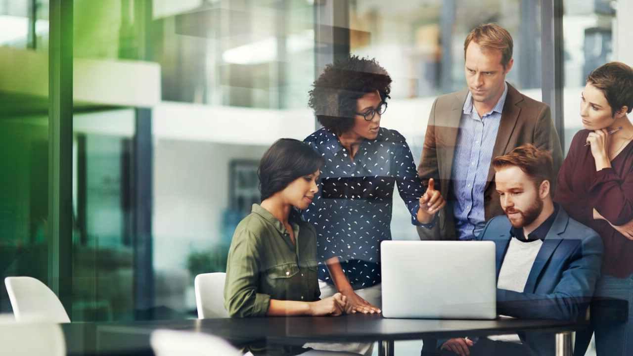 coworkers talking in office with laptop